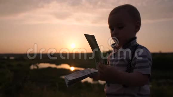一个可爱的小宝宝看着百美元的慢动作很感兴趣视频的预览图