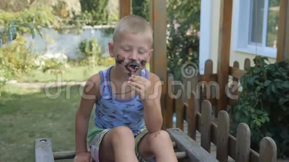 孩子吃冰淇淋男孩用食物弄脏了他的脸孩子吃的是黑华夫饼冰淇淋视频的预览图