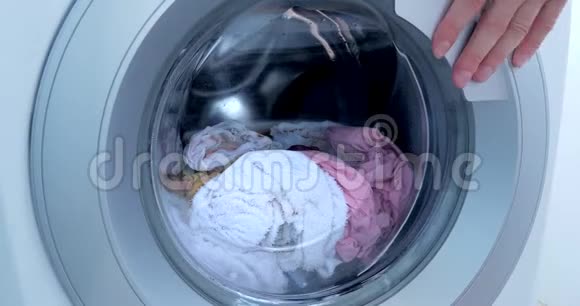 装上洗衣机工业洗衣机洗彩色衣服和白色亚麻布白色条纹衣服视频的预览图
