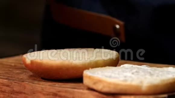 厨师把酱汁放在汉堡的面包上库存录像厨师为汉堡准备酱汁然后穿上新鲜的视频的预览图