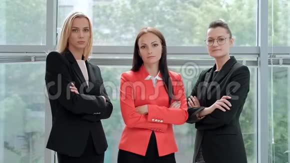 三位年轻漂亮的女士穿着西装在一间轻便办公室的背景下摆姿势主管和下属视频的预览图