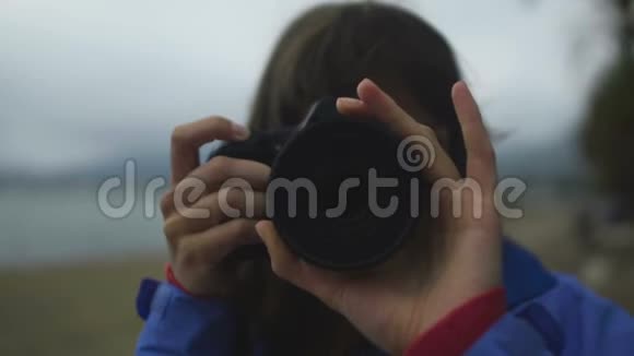 女记者在寒冷的天气在海滩拍照镜头特写视频的预览图