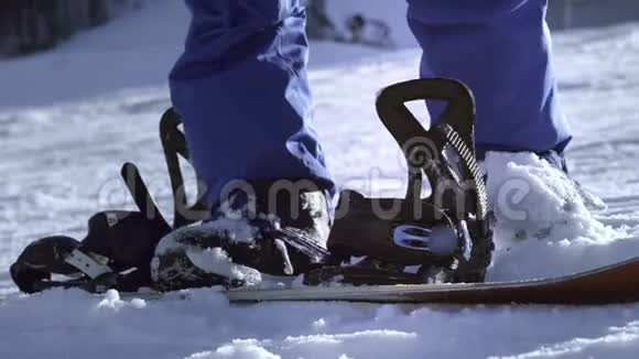 职业骑手把滑雪板放在脚上扣件准备滑雪或滑雪板喜欢冬季运动视频的预览图