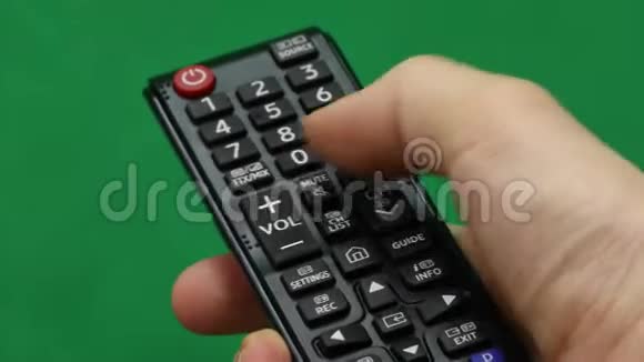男人手大型遥控器右手绿色屏幕按下按钮视频的预览图