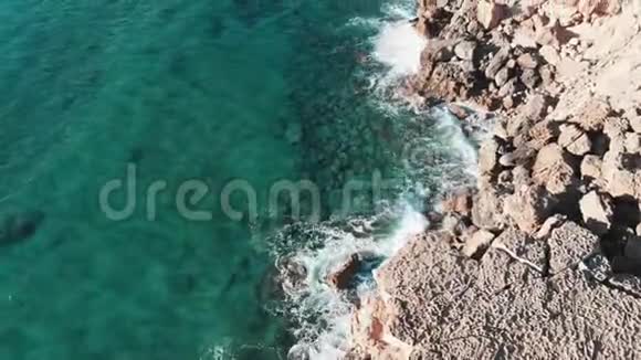 惊涛骇浪撞击岩石海岸的高空俯视图无人机拍摄的海浪碰撞岩石悬崖泼水视频的预览图