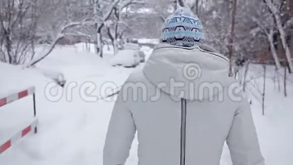冬天一个女孩走在路上全在雪地里从后面看视频的预览图