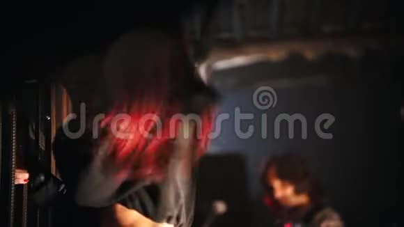一位红发女子摇滚歌手在俱乐部的舞台上演唱视频的预览图