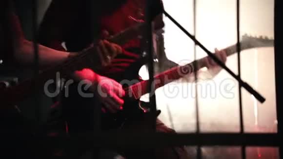 吉他手热情地在舞台上用黑色吉他演奏吸烟阶段视频的预览图