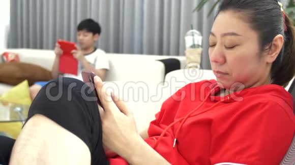社会忽视主义低头族亚洲家庭母子在家一起使用手机视频的预览图