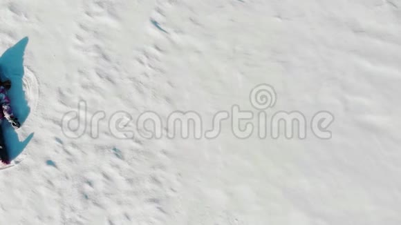 儿童躺在白雪之上的空中景色视频的预览图