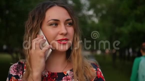 美丽的高加索女人在城里的智能手机上聊天一个穿着亮裙子的女人里面装着智能手机视频的预览图