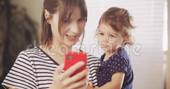 快乐的母亲和宝贝女孩在智能手机上进行视频聊天视频的预览图