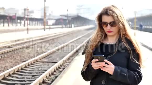 女人用电话进入火车站视频的预览图