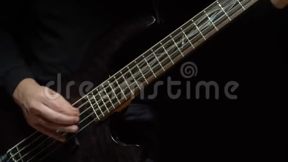 人弹低音吉他黑暗的背景慢动作视频的预览图