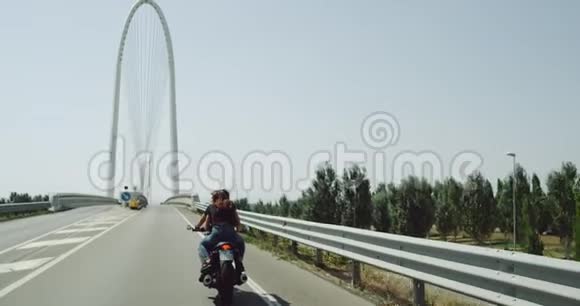 在一个阳光明媚的完美日子里年轻夫妇骑着摩托车在高速公路上兜风视频的预览图