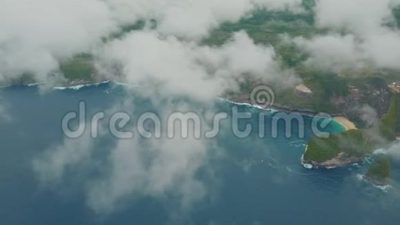 从空中俯瞰蓝色的海洋波浪热带岛屿云层中有山脉视频的预览图