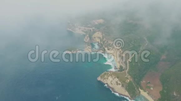 从空中俯瞰蓝色的海洋波浪热带岛屿云层中有山脉视频的预览图