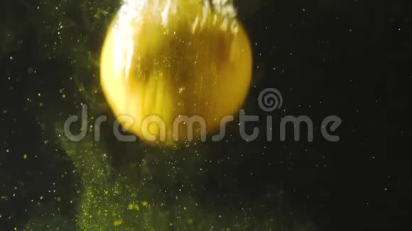 新鲜的柠檬掉进水里黑色背景上有花粉柠檬在水中新鲜有气泡有机食品视频的预览图
