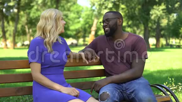 在公园里和坐在长凳上说话的情侣调情视频的预览图
