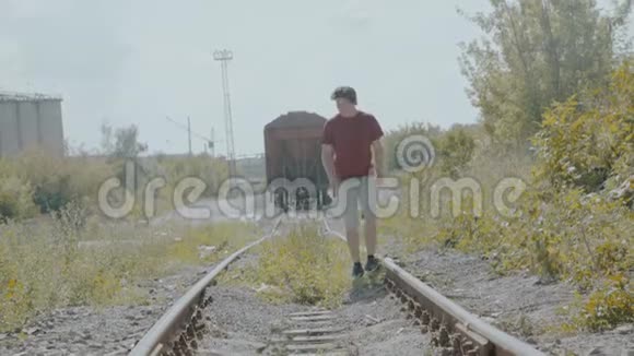 年轻英俊的男孩走在铁路上思考视频的预览图