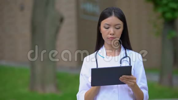 专业女医生在医院公园的平板电脑工作医疗保健视频的预览图