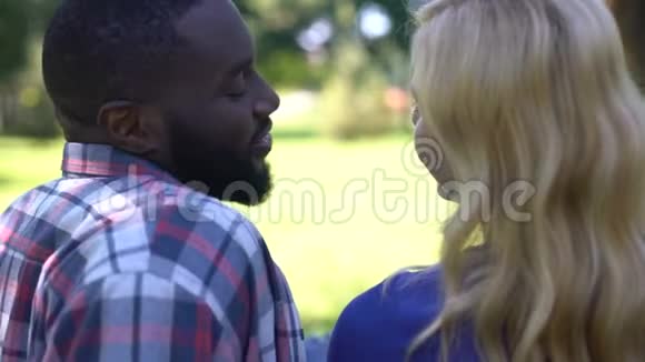 温柔的男人抚摸女朋友的头发对爱情的混血情侣的背影视频的预览图