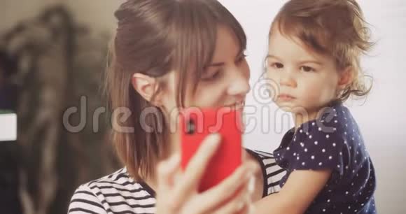 快乐的母亲和宝贝女孩在智能手机上进行视频聊天视频的预览图