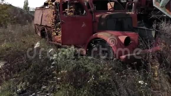 旧的生锈废弃汽车的特写镜头车上有剥落的油漆站在户外的木头上视频的预览图