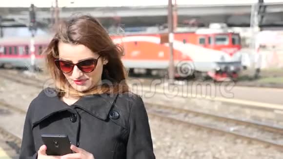 使用手机进入火车站的女孩视频的预览图