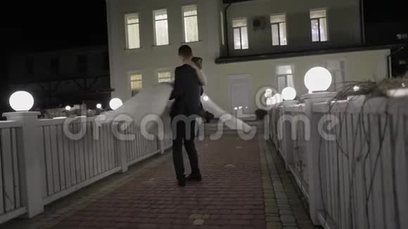 在寒冷的夜晚新娘在一座挂满许多灯笼的桥上露宿秋天视频的预览图