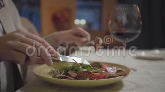 年轻女子的手切着美味的鲜肉放在盘子里蔬菜紧紧地放着晚餐在视频的预览图