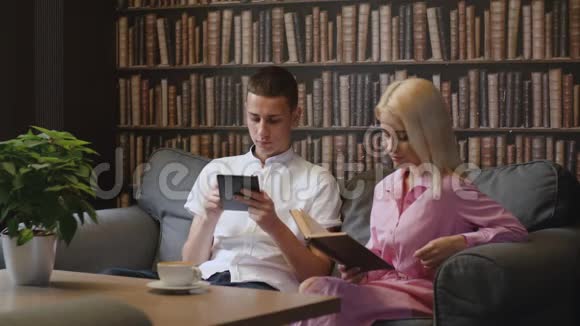 一对夫妇在咖啡厅阅读电子图书和实物印刷书视频的预览图