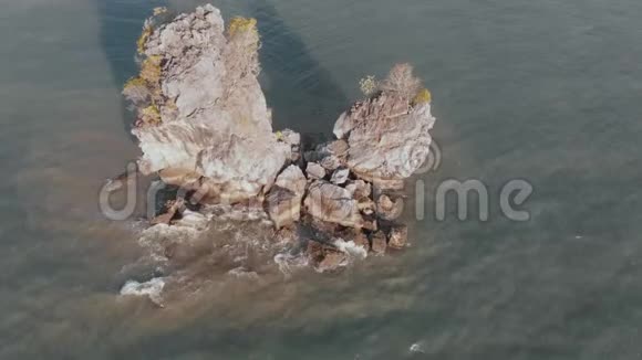 海浪拍打在马六甲海峡的岩石上飞行在无人机上相机平稳上升俯瞰谭戎湖海滩视频的预览图