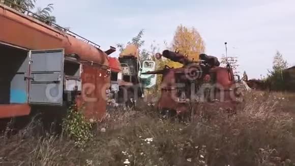 旧的生锈废弃汽车的特写镜头车上有剥落的油漆站在户外的木头上视频的预览图