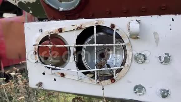 旧的生锈废弃汽车的特写镜头带有剥落的油漆站在户外的木头上视频的预览图
