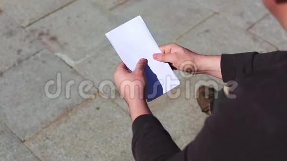 一个年轻人正在检查信封里的钱他在数视频的预览图