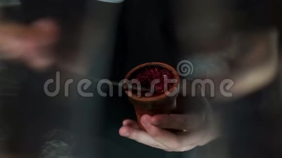 一个男人手把水果烟草放在一个石沙的碗里准备胡克视频的预览图