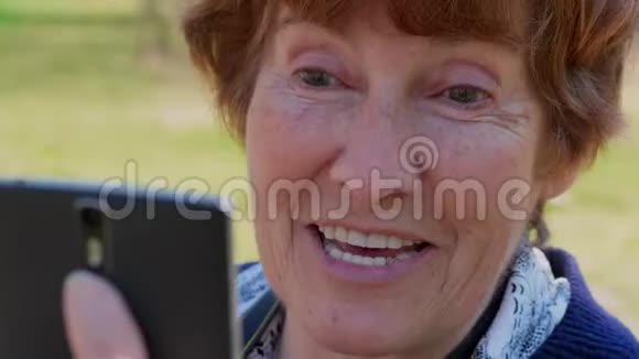 通过移动视频应用程序特写老年女性谈话微笑视频的预览图