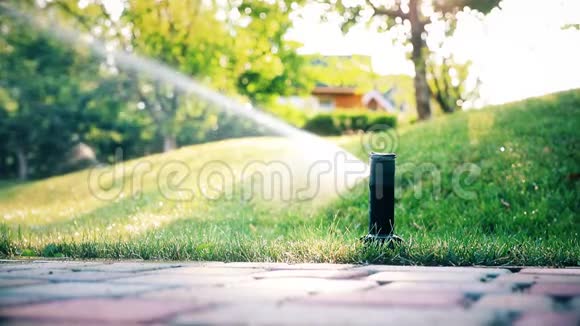采用不同喷头的自动灌溉系统在炎热的夏季傍晚给花园和绿草草坪浇水视频的预览图