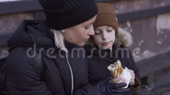 年轻的白种人女人和男孩在冬天在户外吃热狗和喝咖啡视频的预览图