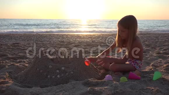 日落海滩儿童玩沙城堡海岸女孩4K视频的预览图