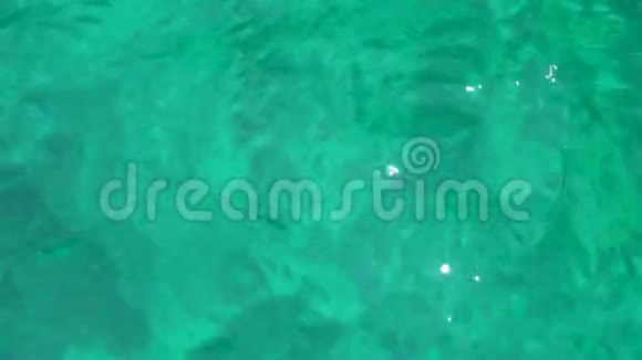 清澈湛蓝的海水给了一个绿色的色调小浪上阳光的刺眼视频的预览图