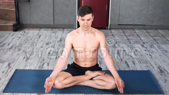 职业瑜伽男练瑜伽在莲花位置在垫子全射视频的预览图