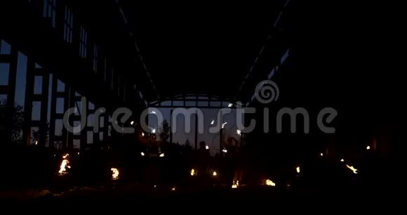 一群人带着火和火把在日落时分在机库里慢悠悠地跳舞消防表演视频的预览图