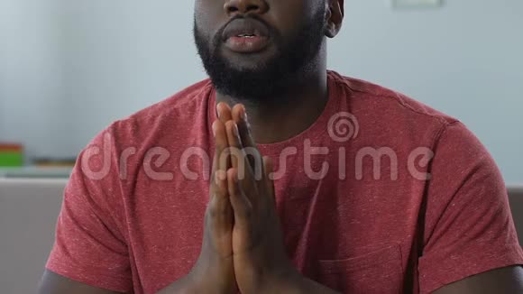 非裔美国人在电视上看足球比赛祈祷取得好成绩视频的预览图