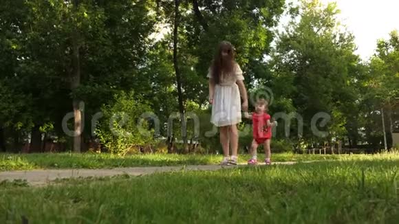 宝贝迈出第一步牵着妈妈的手在公园里散步视频的预览图