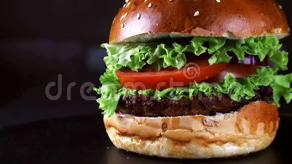 汉堡在黑色背景上的特写蔬菜西红柿和鸡肉是汉堡的原料快餐视频的预览图