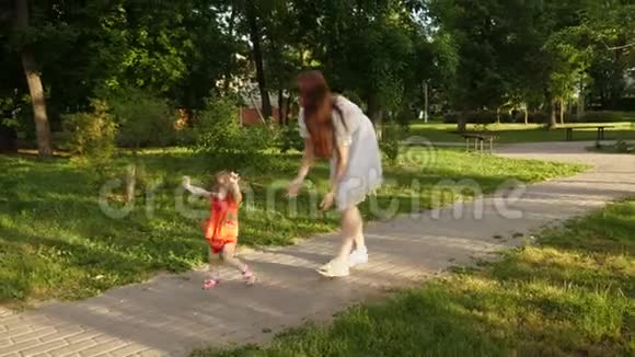 妈妈和她的小女儿在夏天公园玩第一步宝宝和妈妈在一起妈妈和孩子在路上视频的预览图