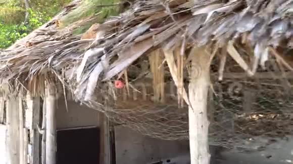 用渔网沿着茅草屋顶拍摄竹屋岛上废弃的建筑视频的预览图