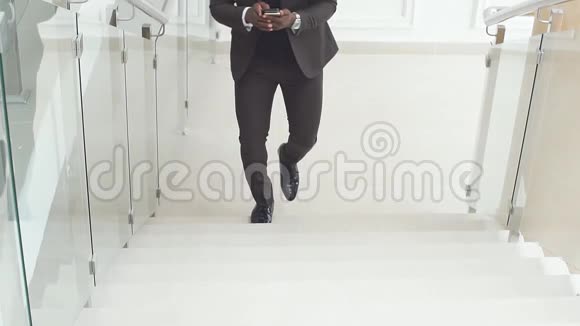 一个黑人用他的手机做生意慢动作一位非裔美国人的商业专家在他的手机上工作视频的预览图